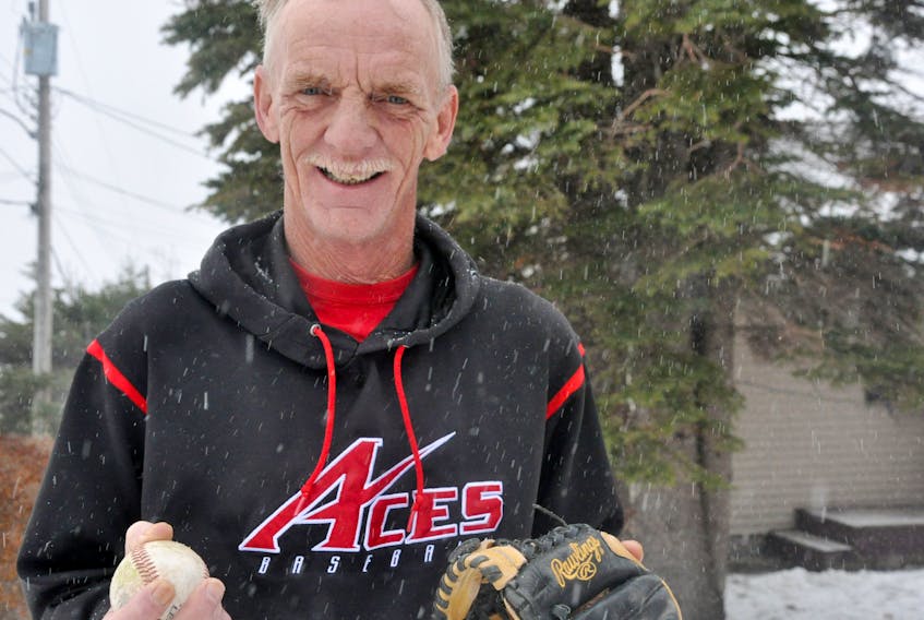 Even posing for a photo in the snow in his yard on Dec. 4, Rob Myrden is all smiles with a ball and glove in his hands.