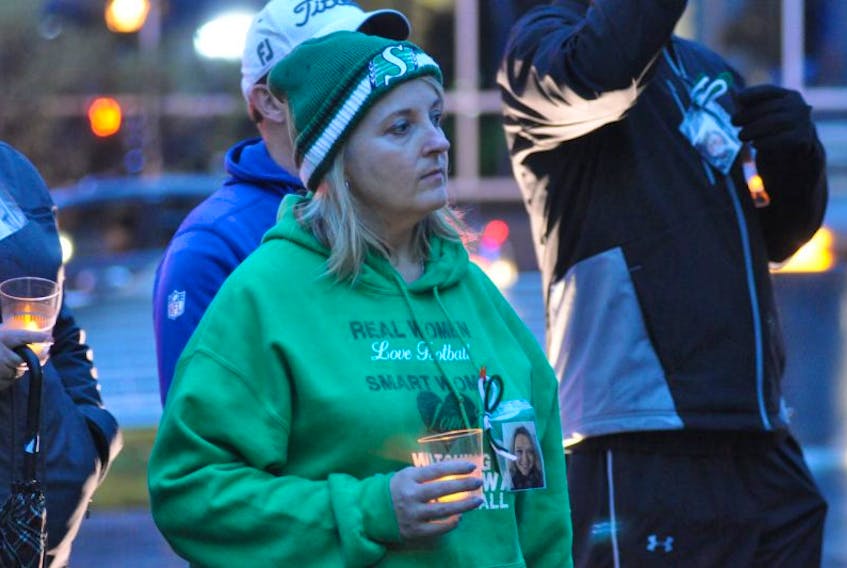 Darlene Felix holds a candle at the vigil held after the World Suicide Prevention Day walk in Corner Brook on Tuesday night. Hanging from her hoodie is a picture of her sister, Michelle Philpott, who died on May 23.