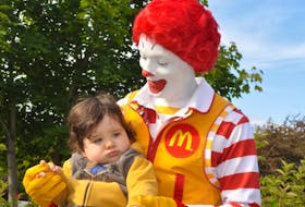 Ronald McDonald poses for a picture with 17-month-old Obie Broadbent before the start of the Red Shoe Crew-Walk for Families at Margaret Bowater Park in Corner Brook on Saturday.