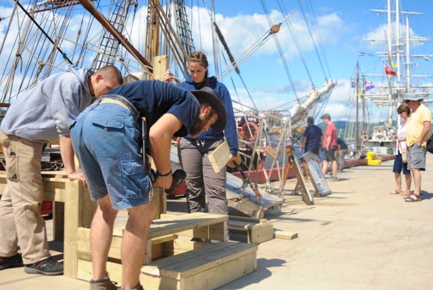 Crewmembers of tall ship Europa break down steps in preparation of departing Corner Brook following a three-day visit Monday. In the background, members of the general public take some final looks and tours of the four other ships that were also in port.