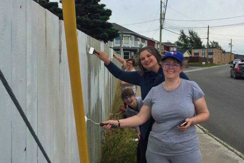 From front, Paula Sheppard Thibeau, Irene Barrett, Emma Barrett, and Mary Cashin were among a group of woman who painted a fence in the St. Marks Avenue area of the city on Sunday to cover up a vulgar statement.