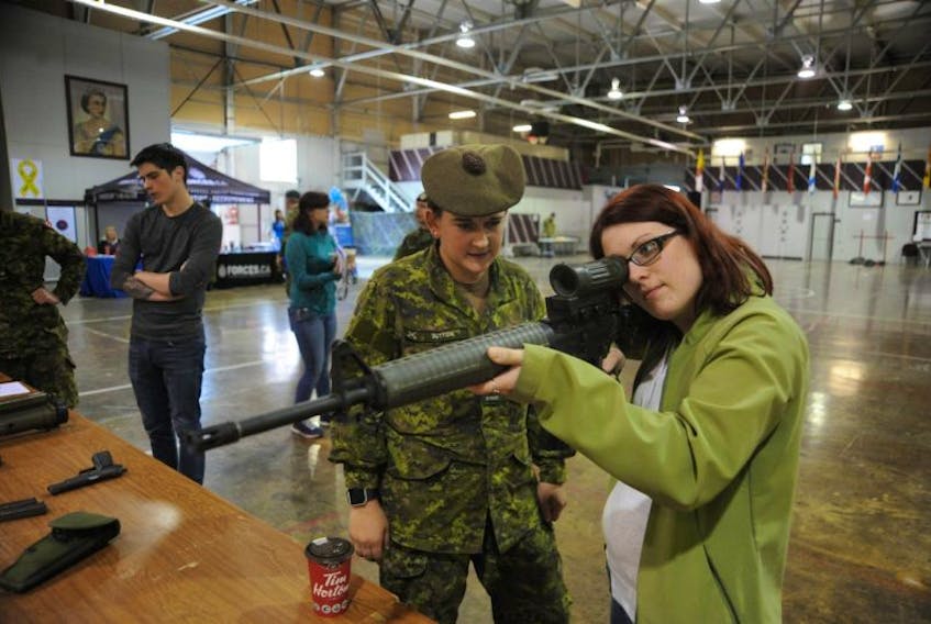 Leah Carberry of Corner Brook, right, got to see what it’s like to hold a C7 rifle during the Canadian Army Reserve’s open house event at the Gallipoli Armoury in Corner Brook Saturday. Showing her the proper way to hold the gun is Cpl. Shellbie Sutton.
