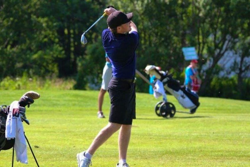 Golfer Andrew Bruce follows through a tee-off and watches his ball sail over the green.