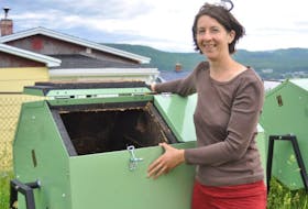 Katie Temple, executive director of the Western Environment Centre, checks one of the composters the centre has located at the Brandon Municipal Playground off Batstone’s Road.
