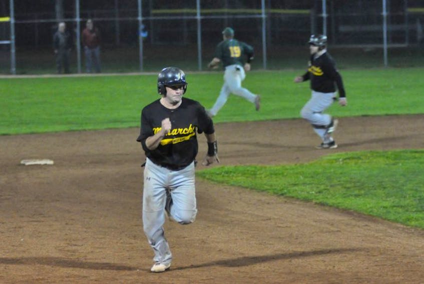 West Side Monarchs’ Sean Mitchell scampers towards third base and will eventually score as the base runner advances behind him during Game 3 of the Corner Brook Molson Senior Baseball League final versus the Veitch’s Ultramar Hawks at Jubilee Field on Thursday night.
