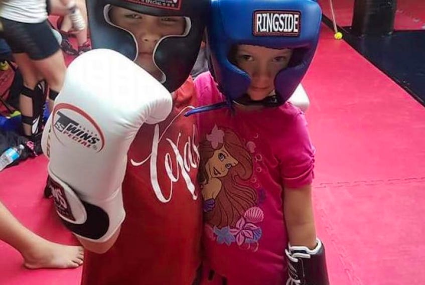 Eva, left, and Sophie Willis are shown in their kickboxing gear at Brake's Gym.