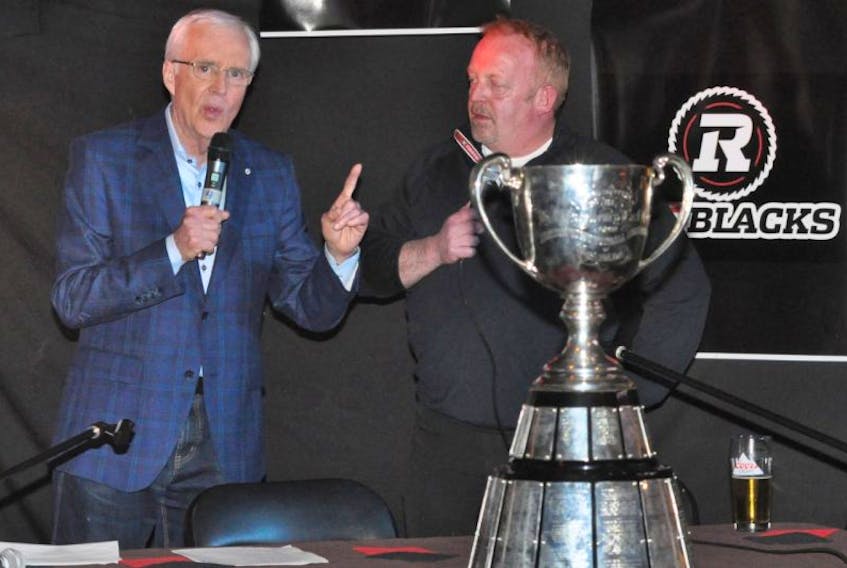With the Grey Cup in the foreground, CTV and TSN sportscaster Brian Williams, left, speaks with Ottawa Redblacks majority owner Jeff Hunt, a Newfoundlander, during the Quarterback Club event, also featuring Redblacks players Greg Ellingson and Brad Sinopoli, at Whelan’s Gate pub on Tuesday night.