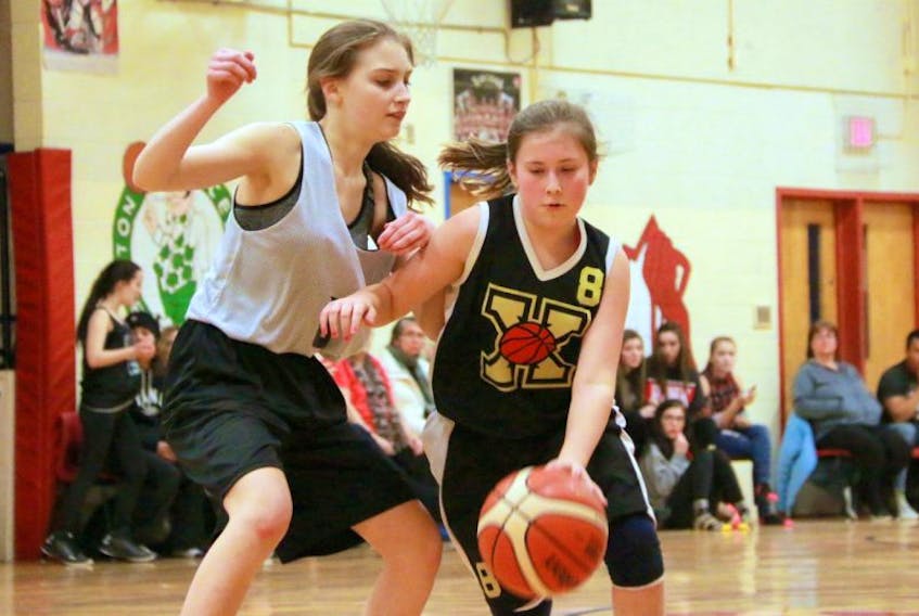 Corner Brook Intermediate Grade 7s’ Hope Evoy (left) defends against Xavier Grade 8s Paige Bishop during championship game action from the West Coast Provincial Grade 8 Girls basketball tournament at Xavier Junior High in Deer Lake.