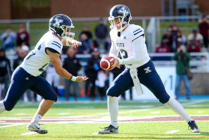 X-Men quarterback Quinn Stewart makes a hand-off to first-year running back Chase Bowden in a 14-4 season-ending win over the Saint Mary’s Huskies. Nick Pearce