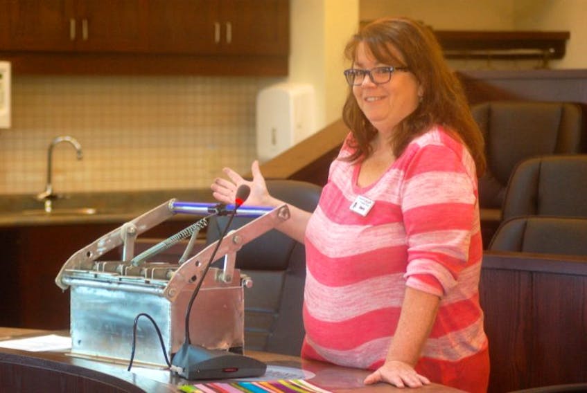 <p>Sherry Robertson, executive director for the Yarmouth Life Skills for Disabled Adults Association, demonstrates a fire starter brick press to the Yarmouth municipal council last Wednesday.<br />CARLA ALLEN PHOTO</p>