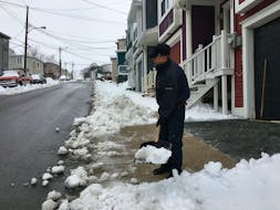 A homeowner shovels snow in downtown St. John's Wednesday. He declined to give his name, fearing a social backlash because of COVID-19 panic. BARB SWEET/THE TELEGRAM