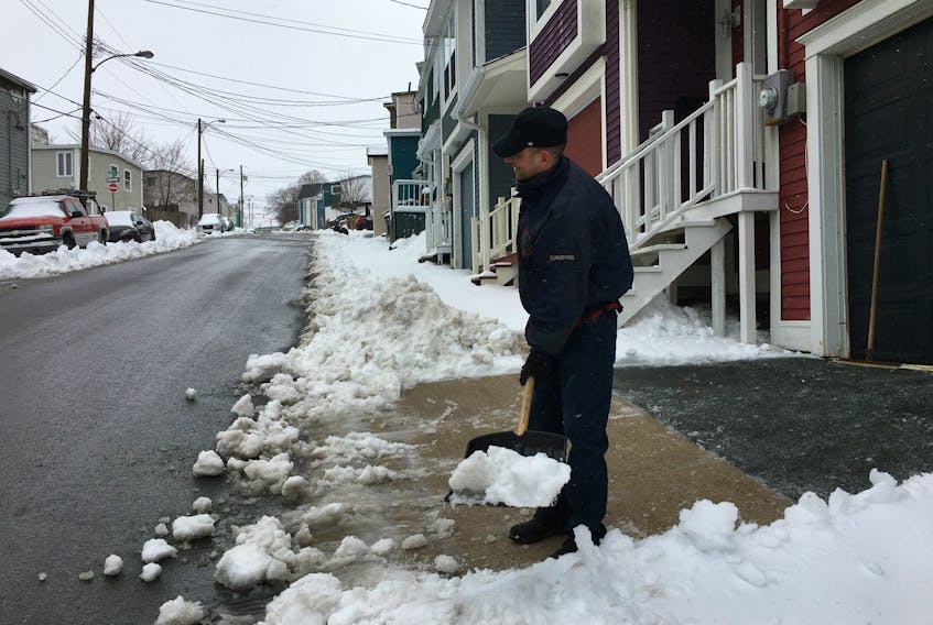 A homeowner shovels snow in downtown St. John's Wednesday. He declined to give his name, fearing a social backlash because of COVID-19 panic. BARB SWEET/THE TELEGRAM