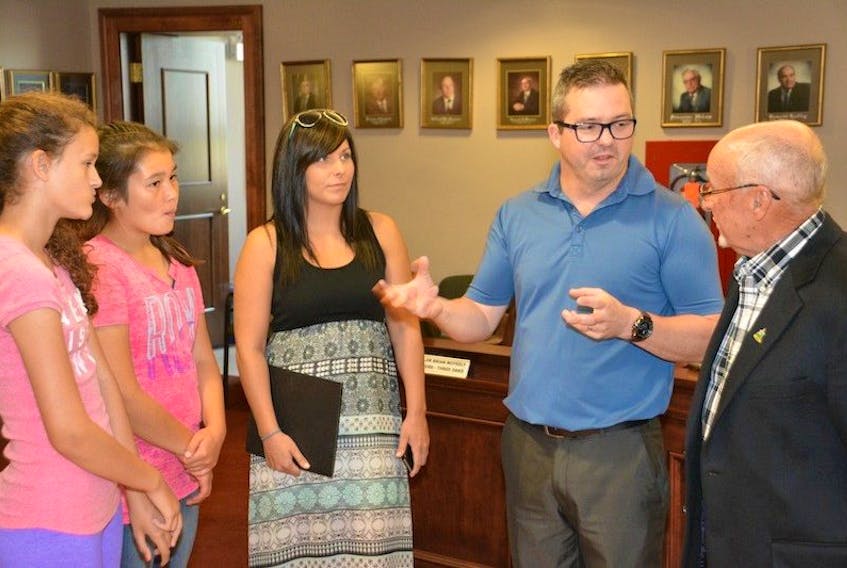 <p><span class="BodyText">Program participants Emily McKenna, 12, left, and Tori Clark, 12, along with Kate Gaudet, Young Leaders program co-ordinator, listen as Jason Gaudet, also with the program, explains its merits to Summerside Mayor Bill Mayor during a visit to City Hall recently. </span></p>