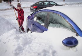 In this file photo, masters student Lyndsay Bennett digs her car out of the snow drifts that enveloped her vehicle overnight on Arthur Street in Ottawa as the city crawls out from under a major winter storm last February. Wayne Cuddington / Postmedia News