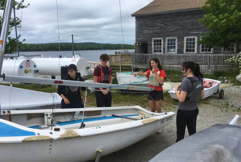 SHYC Sailing Academy 2020 Coaching Staff check out the rigging on one of the boats that make up the Academy fleet. Rob Stork photo