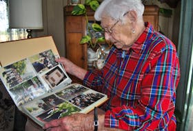 Betty Lovitt looks through an album of photographs taken over the years at reunions of the West Nova Scotia Regiment. Lovitt is a World War II war bride. KATHY JOHNSON PHOTO