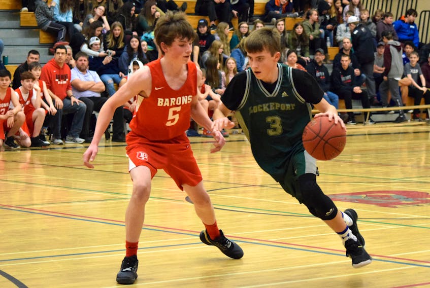 The Barrington Barons’ Doug Symonds (#5) tries to block Lockeport’s Avery Lloyd as he breaks down the court in the opening game of the BMHS Junior Boys Winter Classic Basketball Tournament. KATHY JOHNSON PHOTO