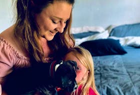 Jessica Lewis and her daughter Arizona get to know their new pit bull puppy Bronx.  CONTRIBUTED