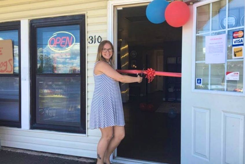 Samantha Theriault cuts the ribbon at the opening of her massage therapy business, At Ease Wellness Studio.