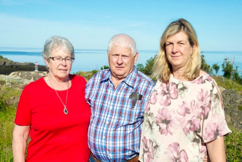 Marilyn and Lewis Walker stand with Elizabeth Lore in front of Centreville Harbour in Trout Cove, on the Bay of Fundy, one of the two bays surrounding the Digby Neck.
