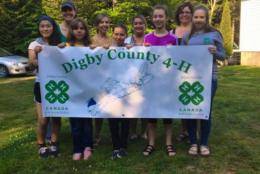 Members of Digby County's 4H Club and Digby Care 25 stand behind the county’s banner. Digby County 4H will begin building a new barn in spring 2018 for all its clubs to use.