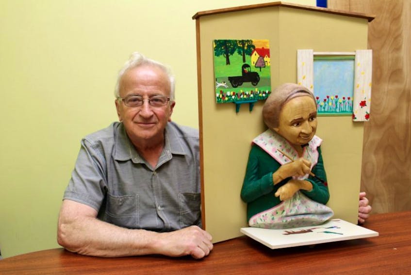 Yarmouth-area carver Bruce Jacquard with a piece he did on Maud Lewis.