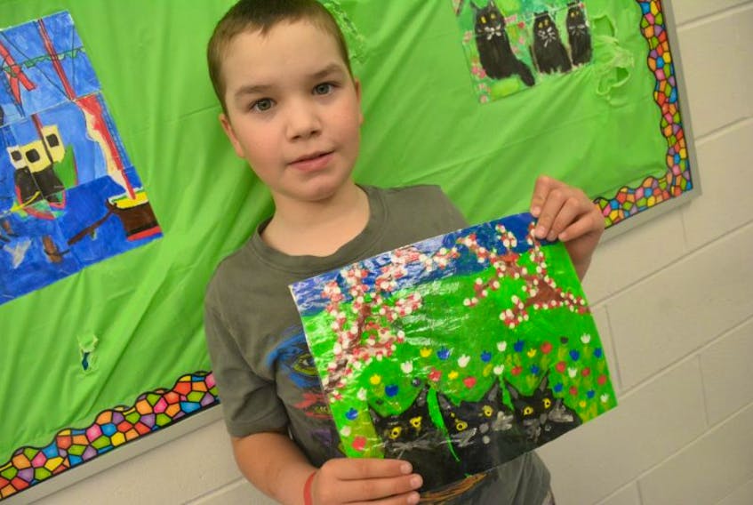 Grade 5 special needs student Cirdan MacLeod with a replica he painted himself of a Maud Lewis painting.