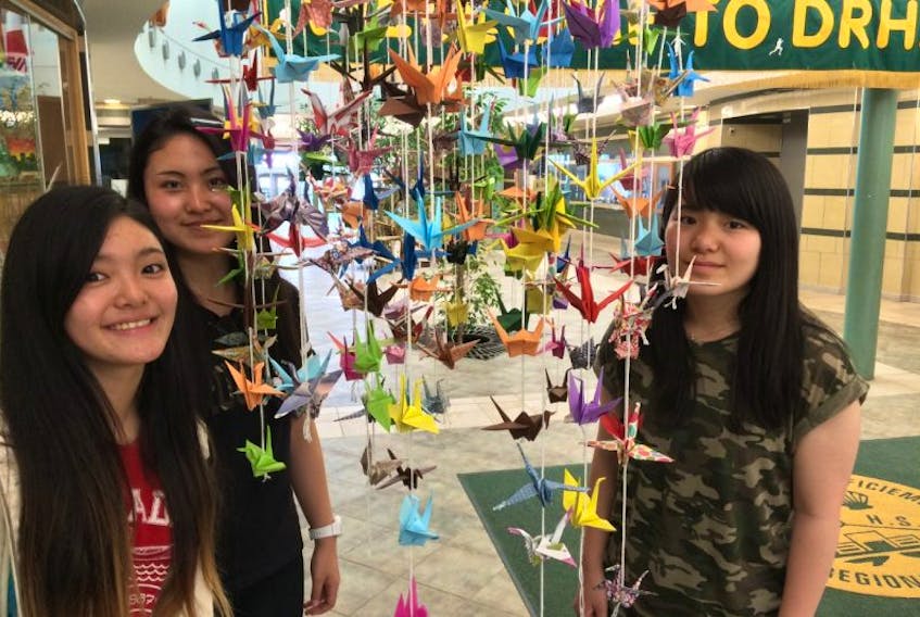 DRHS international students Nao Ishizu, Miki Yoshida and Risa Tanima check out some artwork created in a DRHS art class – the international students helped out with last year’s event, hosted at NSCC.