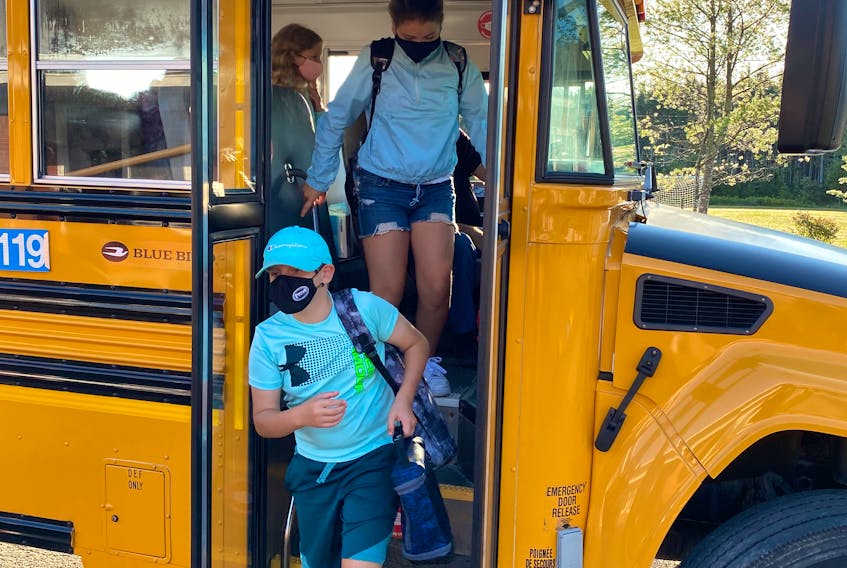 Students wear their masks as they exit the bus for a full day at Riverside School in Albert Bridge. CONTRIBUTED