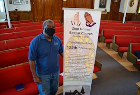 Pastor Brian O. Johnston stands next to a banner in celebration of the church's 125 years. The church has a rich history as historical centre of Truro's Black Community.